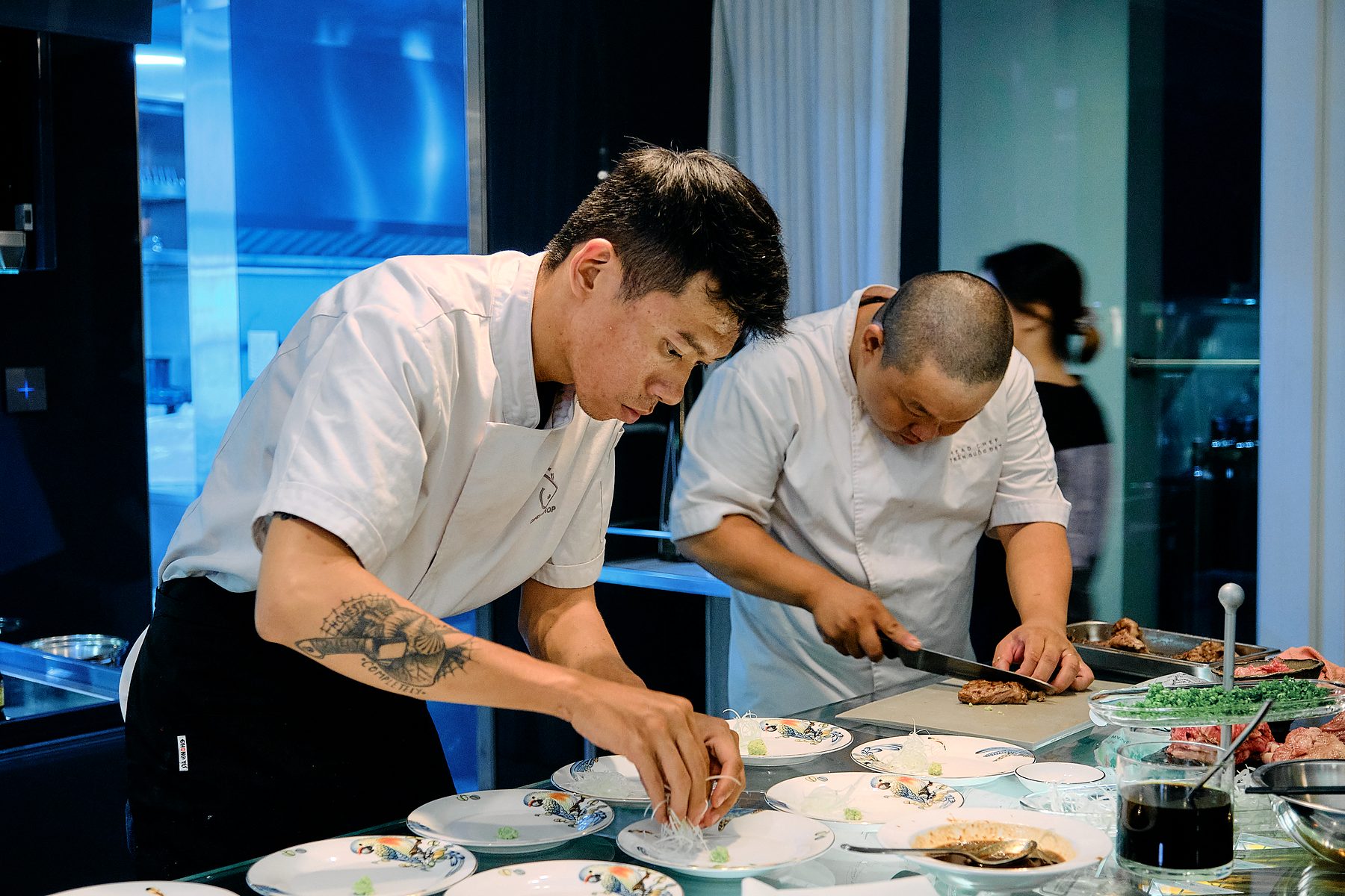 Chef Đạt and a colleague plating a tasting menu