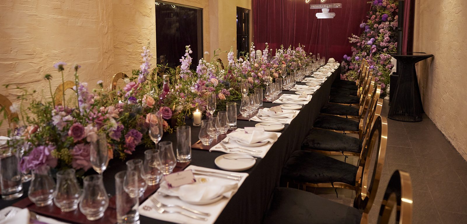 VIP dinner table set with flowers down the centre